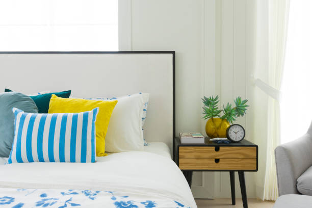 istock Yellow and blue pillows on white bed at home. 1174838753