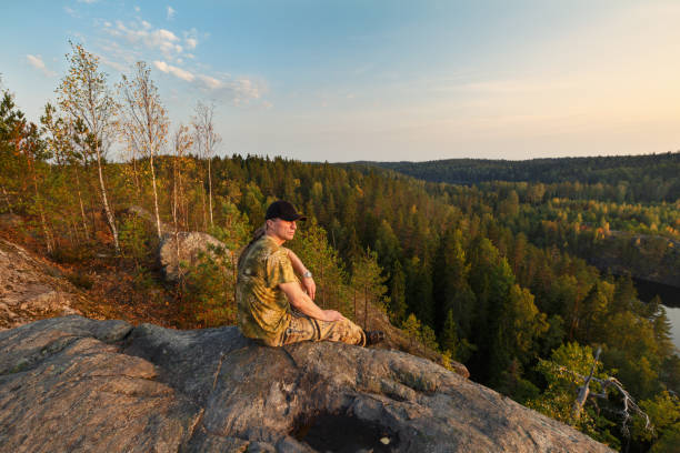 istock A man sits on a rock, looks at the horizon 1174841457