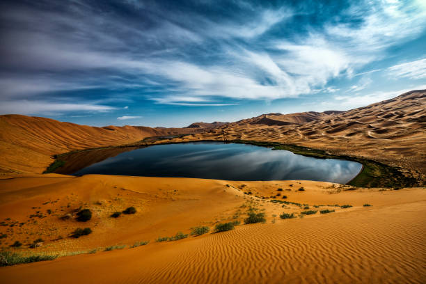 Mirrored vibrant skies on this mysterious lake at the Badain Jaran Desert in Inner Mongolia, Western China.