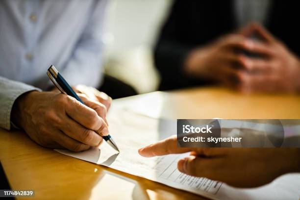 Close Up Of Unrecognizable Person Signing A Contract Stock Photo - Download Image Now