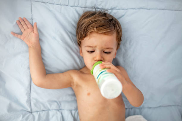 istock Baby boy lying down and drinking from a bottle 1174843215