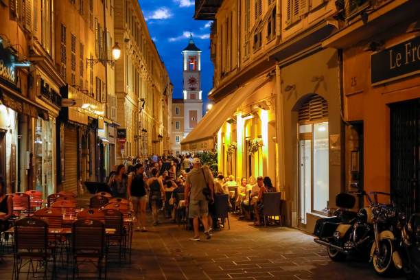 many people spend time in outdoor cafes at night. the city of nice is located on the french riviera in the provence-alpes-cote d'azur region - city of nice restaurant france french riviera imagens e fotografias de stock