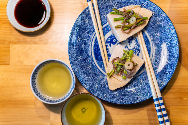 tradycyjny japoński talerz na drewnianym stole z wiosennym daniem warzywnym z pędów bambusa takenoko, sansai dzikie zioła z pałeczkami, zielona herbata sencha w filiżance i sos sojowy - flattop mountain zdjęcia i obrazy z banku zdjęć