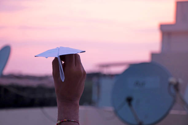 istock Hand trying to flew a paper aeroplane 1174847047