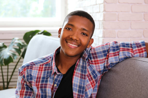 istock Handsome dark skinned guy wearing hipster outfit sitting on sofa at home? 1174847264