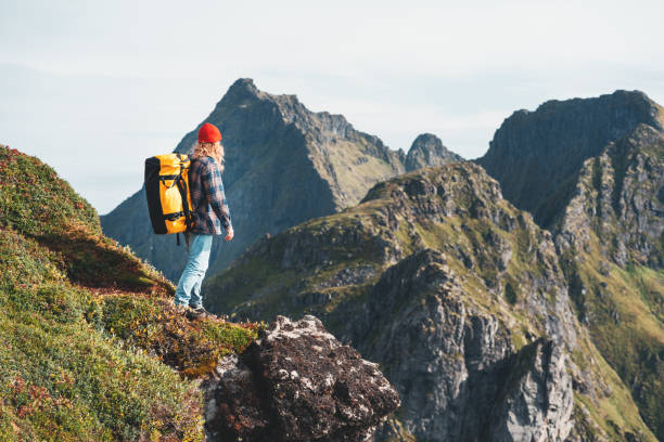 dzielny turysta podróżujący w wysokich górach nad morzem. hipster traveler z plecakiem stojącym na krawędzi skały klifu. styl życia przygoda wanderlust - rock norway courage mountain zdjęcia i obrazy z banku zdjęć