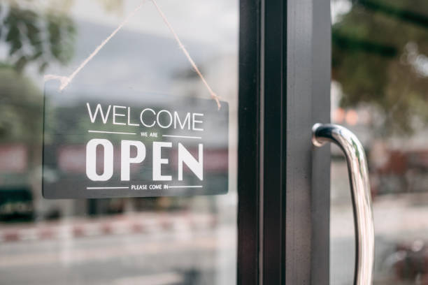 closeup of open and welcome to store sign board at the door. - entrance sign imagens e fotografias de stock