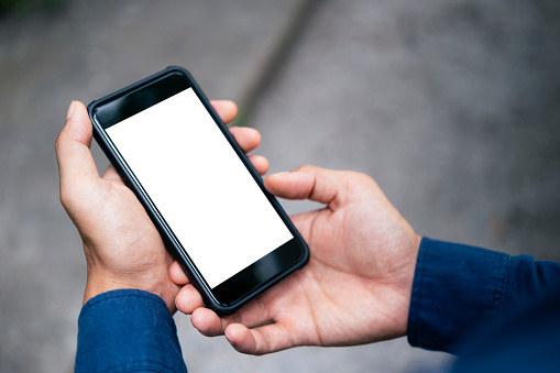 Close up of man hand holding smart phone. Blank screen mockup for graphics display montage.