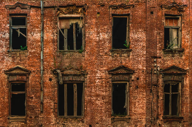 istock Old windows of an abandoned soviet red brick house 1174848435