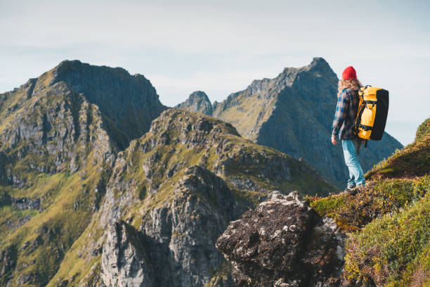 istock Alone professional traveler with backpack on high mountain standing on the edge cliff rock and looking away. Adventure lifestyle vacation 1174848490