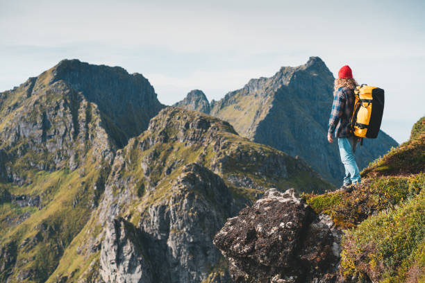 samotny profesjonalny podróżnik z plecakiem na wysokiej górze stojący na skraju klifu i patrzący w przyszłość. przygodowe wakacje w stylu życia - rock norway courage mountain zdjęcia i obrazy z banku zdjęć