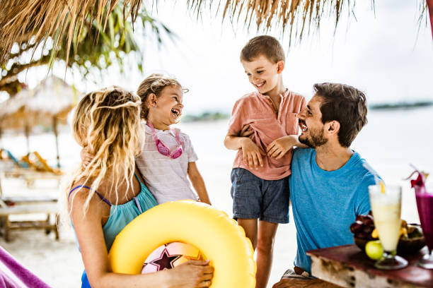 istock Happy parents communicating with their small kids in a beach bar. 1174849572