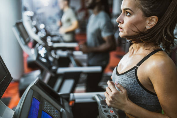 istock Determined female athlete jogging on treadmill in a gym. 1174851309