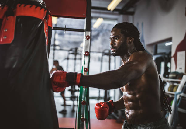 istock Sweaty black athlete exercising boxing in a gym. 1174852146