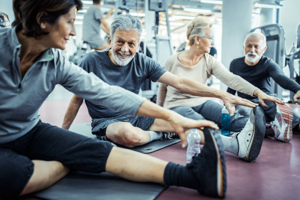 istock Active mature people doing stretching exercises on exercise class in a gym. 1174852207