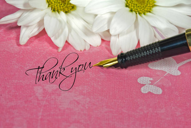 close up of black fountain pen and thank you text with white daisy