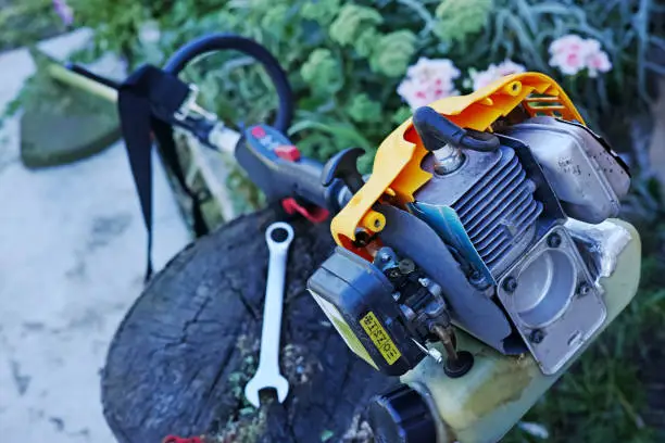 Repairing a manual gas mower outdoors