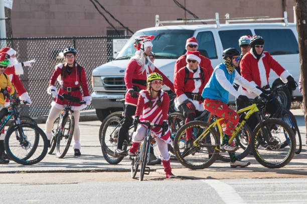 gruppo di persone che indossano costumi di babbo natale in bicicletta ad atlanta - eclectic community foto e immagini stock