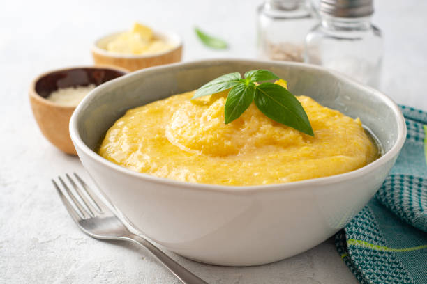 polenta z masłem i parmezanem w misce na betonowym tle - polenta zdjęcia i obrazy z banku zdjęć