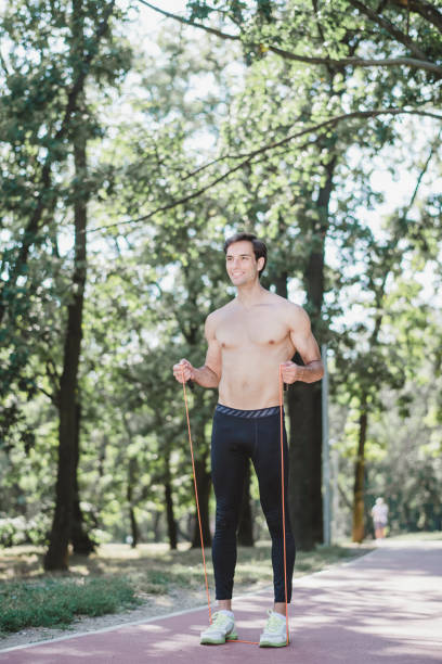 istock Young man exercising jumping rope in nature 1174856349