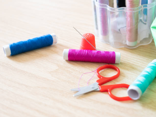 istock Spools of thread, bobbin, scissors and sewing accessories on a wooden background with shallow deep of field 1174858907