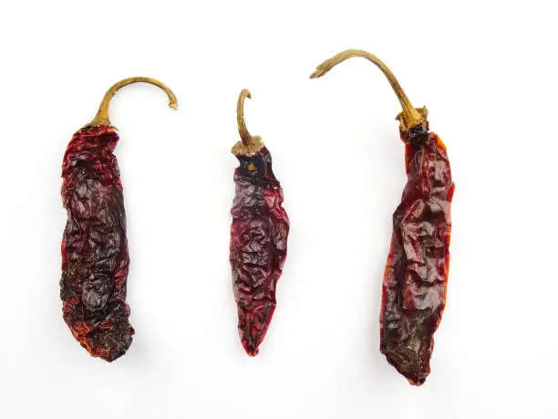 Group Hot Chipotle chilies (dried jalapeño, Morita Variety), isolated on a green background