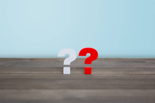 istock White Question Mark and Red Question Mark on wood table 1174862081