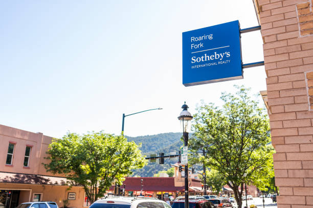 Historic downtown summer street in Colorado with brick architecture and Sotheby's International Realty Glenwood Springs, USA - July 10, 2019: Historic downtown summer street in Colorado with brick architecture and sign for Roaring Fork Sotheby's International Realty garfield county montana stock pictures, royalty-free photos & images