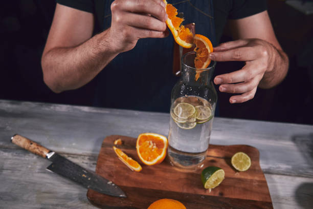 istock Young chef in kitchen squeeze orange and lime for juice. Food concept. 1174864179