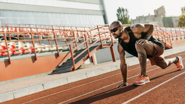 istock Athlete runner doing stretching exercises on the running track 1174864495