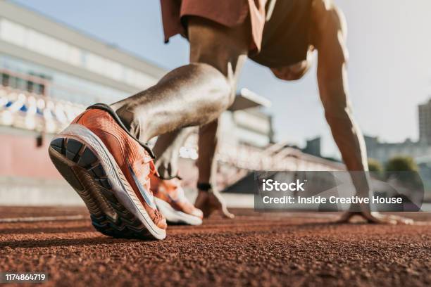 Close Up Of Male Athlete Getting Ready To Start Running On Track Focus On Sneakers Stock Photo - Download Image Now