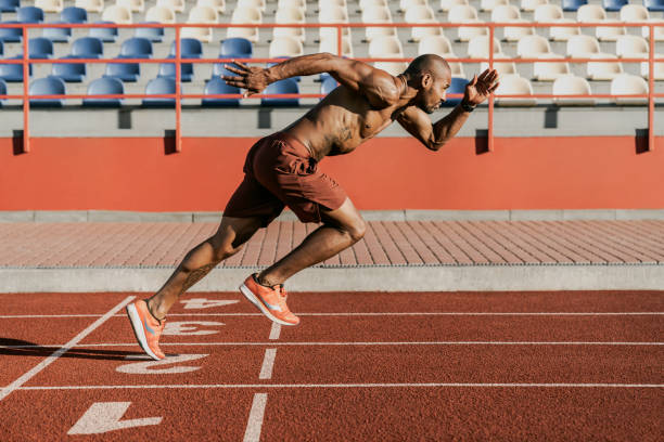 Side view of an athlete starting his sprint on an all-weather running track Running, Athlete, Exercising, Scoring Run, Muscular Build sprint stock pictures, royalty-free photos & images