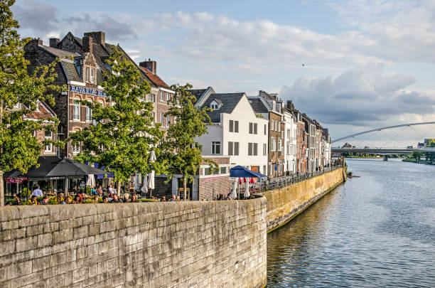 Maastricht, The Netherlands, September 7, 2019: view along the quay at Wyck neighbourhood, with trees, terraces and three or four storey brick houses