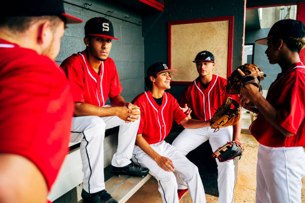 istock Hispanic baseball players relaxing and talking in dugout 1174867064