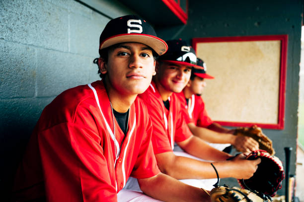 더그아웃에서 벤치에 앉아 있는 젊은 히스패닉 야구 선수들 - baseball sports team teamwork sport 뉴스 사진 이미지