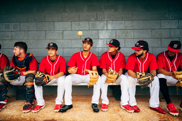 istock Confident young Hispanic baseball players sitting in dugout 1174867080