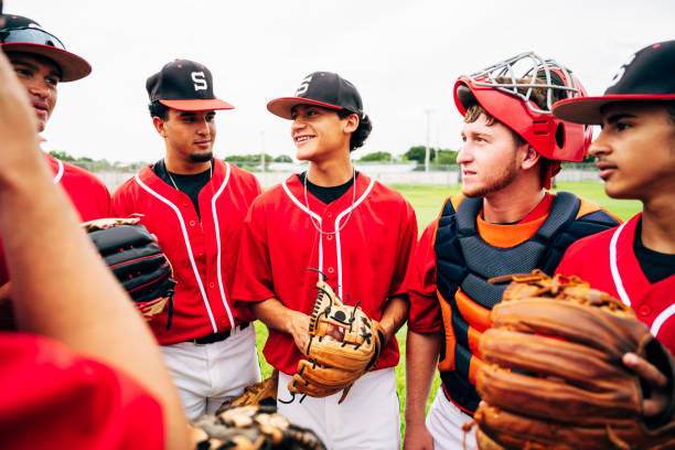 Hispanic baseball team standing together and ready to play Close-up of confident young Hispanic baseball team members standing together warmed up and ready to play. high school baseball stock pictures, royalty-free photos & images