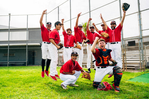 Hispanic baseball teammates jumping and gesturing in victory Outdoor group portrait of excited baseball players jumping and gesturing in celebration of game victory. high school baseball stock pictures, royalty-free photos & images