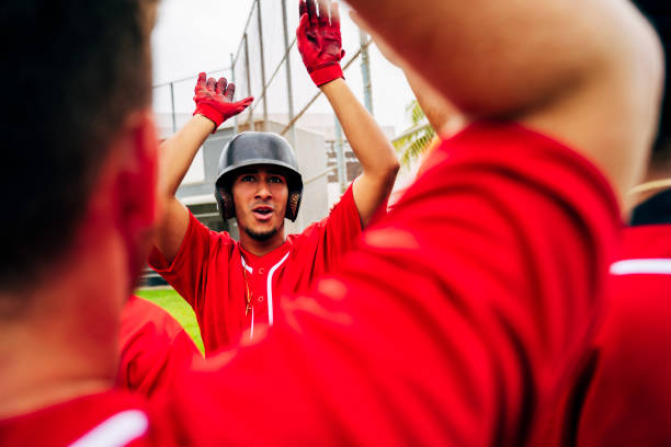 This is an image of a father coaching his daughter at a girls softball game. She's in focus with a relatively shallow depth of field. He's lens blurred but you can imagine him motioning with his hands.