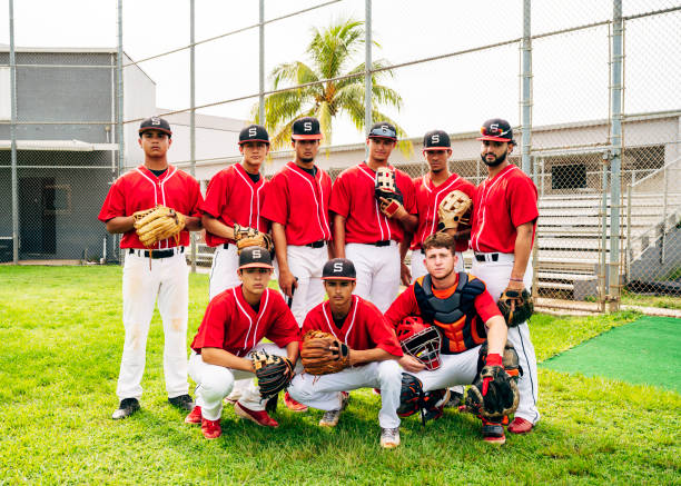 Serious nine-man Hispanic baseball team ready to play Outdoor group portrait of serious-minded young Hispanic baseball team suited up and ready to play ball. Chest Protector stock pictures, royalty-free photos & images