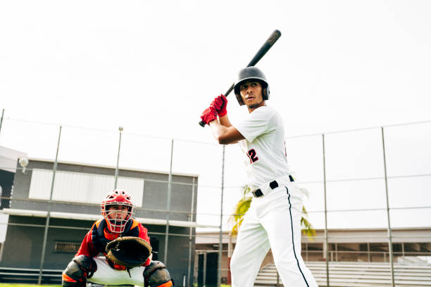 hispanische baseball-schläger und catcher warten auf spielfeld - baseball player baseball sport catching stock-fotos und bilder