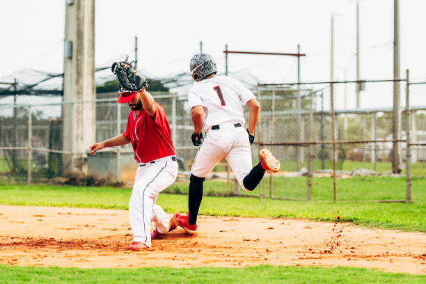 corredor de béisbol tocando corbatas de bolsa con lanzamiento a primera base - baseball league fotografías e imágenes de stock