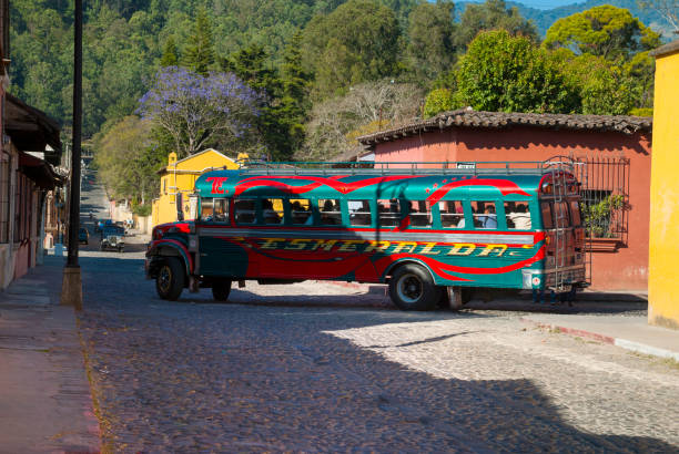 chicken bus in cobbled street, antigua guatemala. - editorial guatemala antigua tourist imagens e fotografias de stock