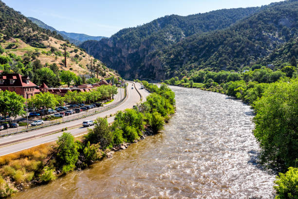 Roaring Fork Colorado river in downtown with water and highway in summer Glenwood Springs, USA - July 10, 2019: Roaring Fork Colorado river in downtown with water and highway in summer garfield county montana stock pictures, royalty-free photos & images