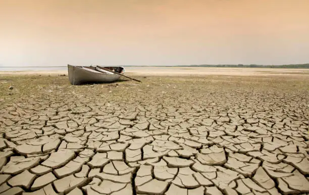 Rowboat on the dried-up lake. water drawn in a lake. Because of climate change, the waters had been withdrawn this year.