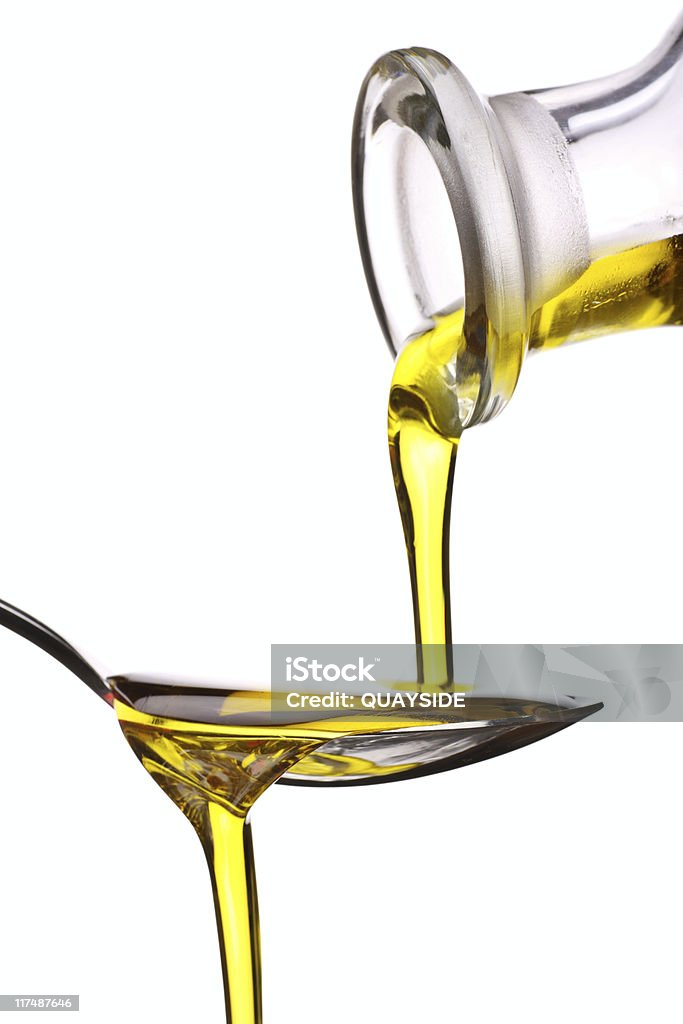 Extra Virgin oil being poured on a spoon extra virgin olive oil being poured onto a spoon Cooking Oil Stock Photo