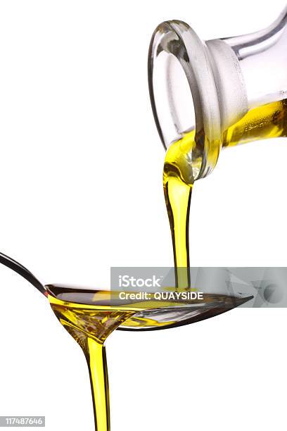 Extra Virgin Oil Being Poured On A Spoon Stock Photo - Download Image Now - Cooking Oil, White Background, Bottle