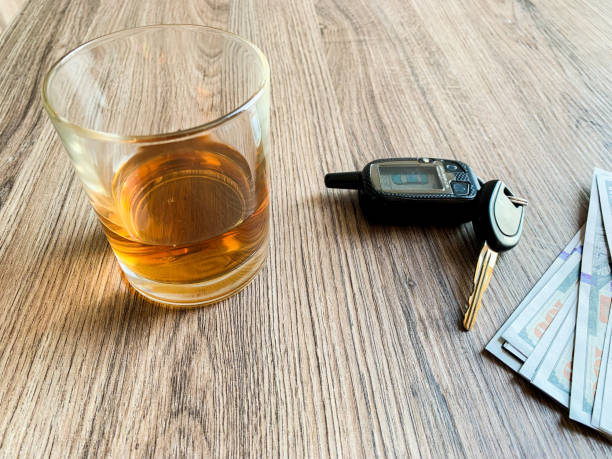 istock Drunk driving concept. Glass with whiskey and car key on the table. 1174879710