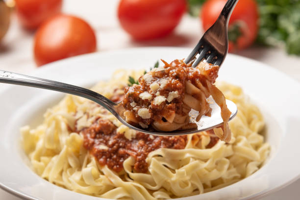 素朴な木製のテーブルの背景に白いプレートにトマトソースとパスタフェットチーネボロネーゼ、柔らかい光 - dishware pasta tagliatelle beef ストックフォトと画像