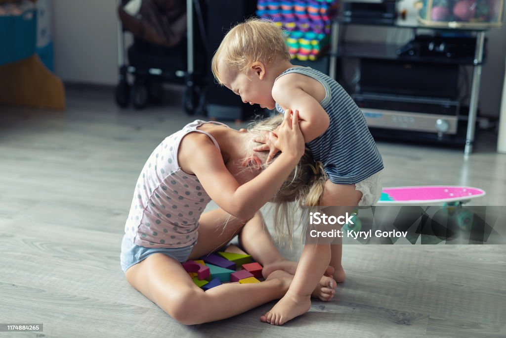 Zwei kleine Geschwister Kinder streiten sich nach dem Spielen im Zimmer im Haus. Weinen beleidigt Kleinkind Junge Streit mit älteren Schwester. Familienrivalität und Generationenkonfliktkonzept - Lizenzfrei Kind Stock-Foto